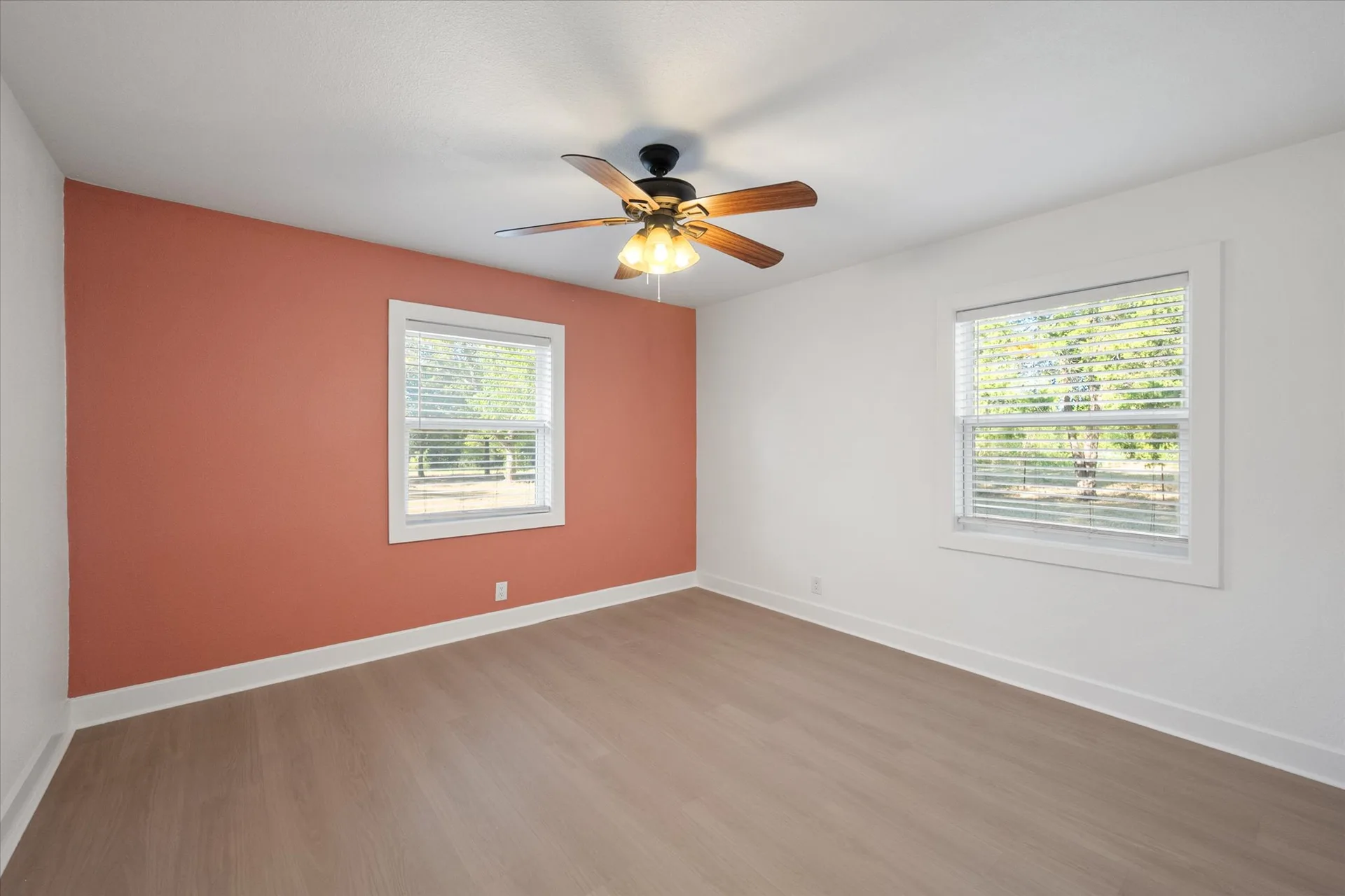 Guest bedroom with a warm terracotta accent wall and natural light