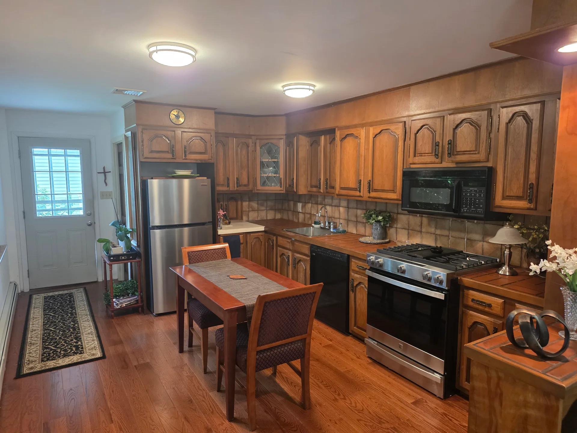 Traditional eat-in kitchen with tile backsplash and stainless steel appliances