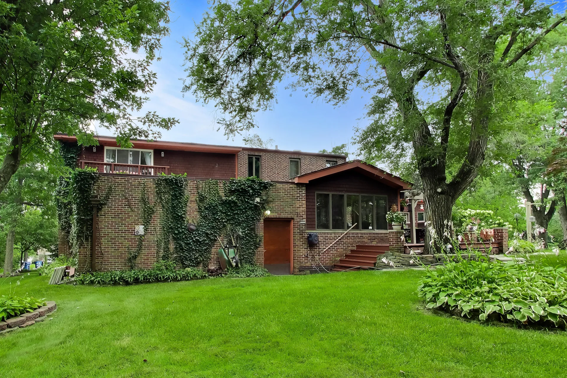 Rear exterior with ivy-covered brick and sunroom steps