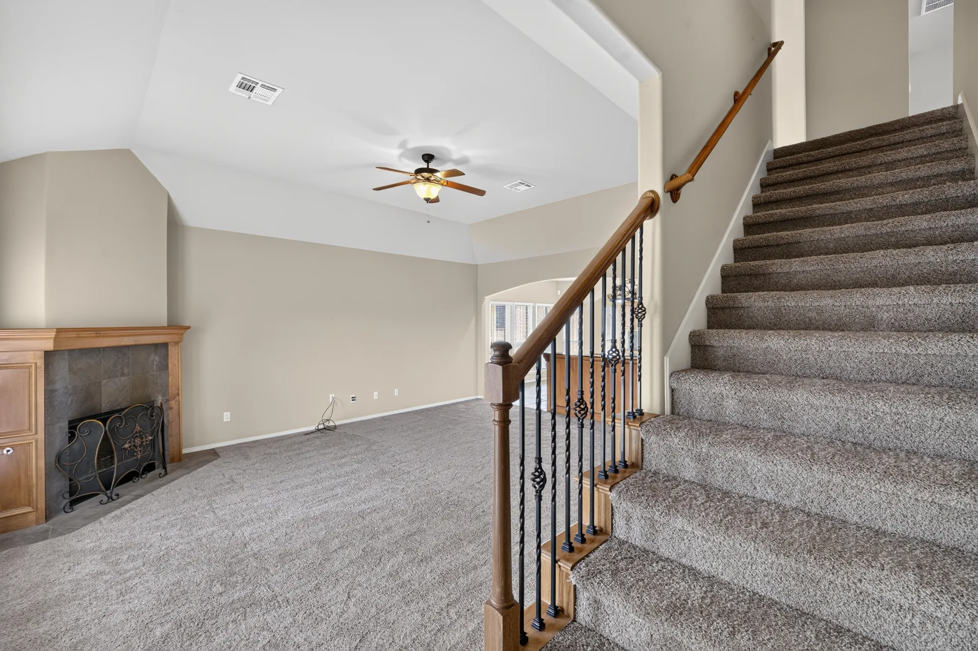 Fireplace, staircase, and vaulted ceiling