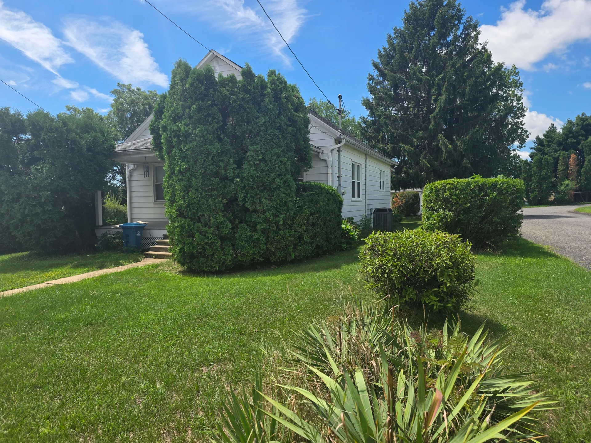 Angled exterior view showing the Cape Cod roofline and front yard
