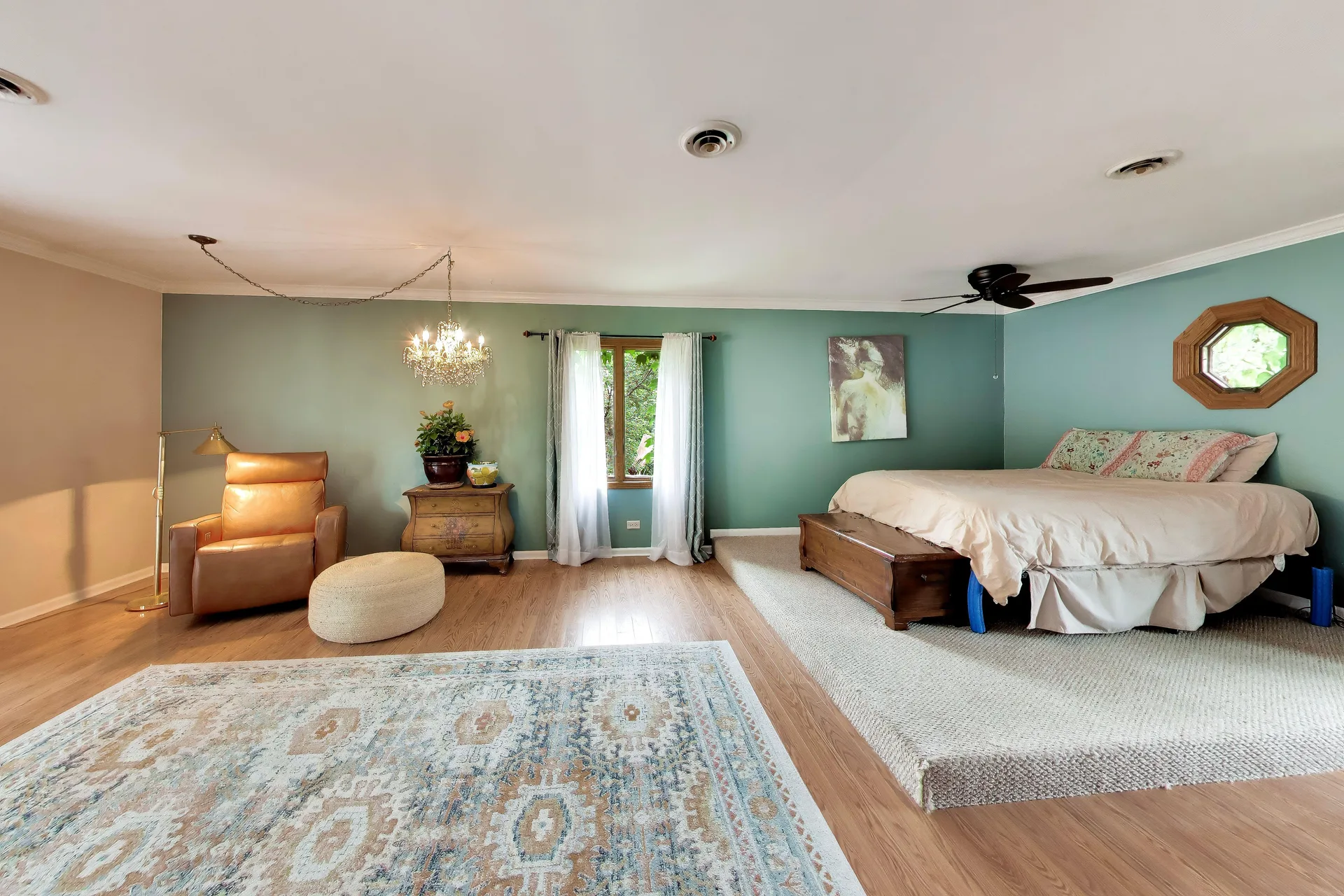 Master bedroom with raised bed platform and teal walls