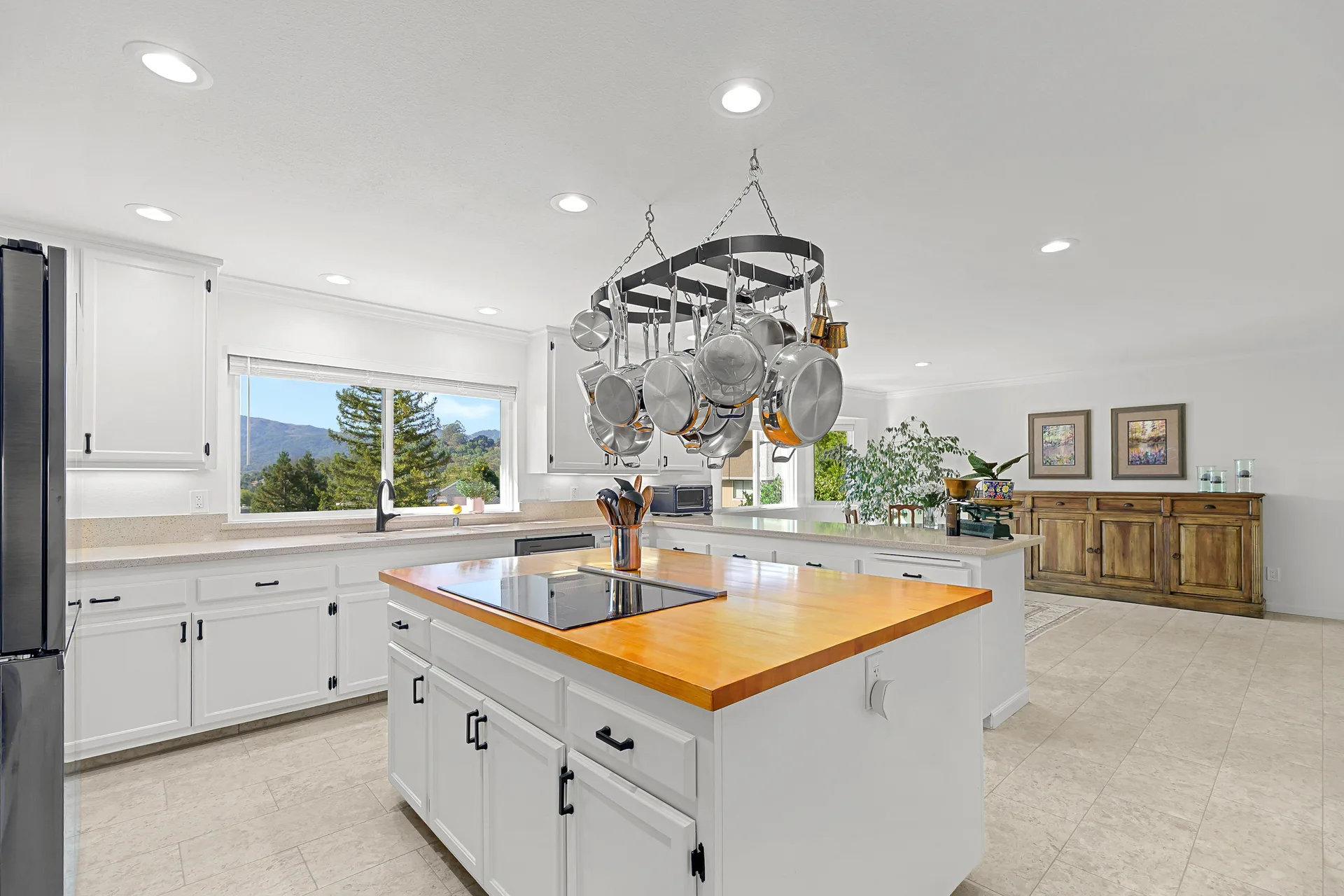 Kitchen at 10 Santa Yorma Ct with white cabinetry, butcher-block island, and mountain views through the window