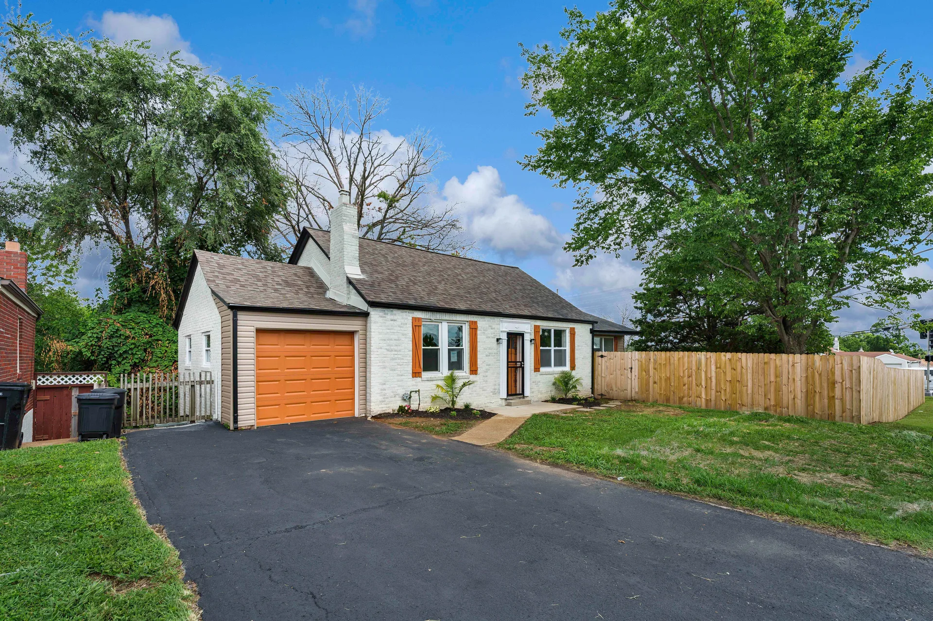 Street-level front view with driveway and privacy fence
