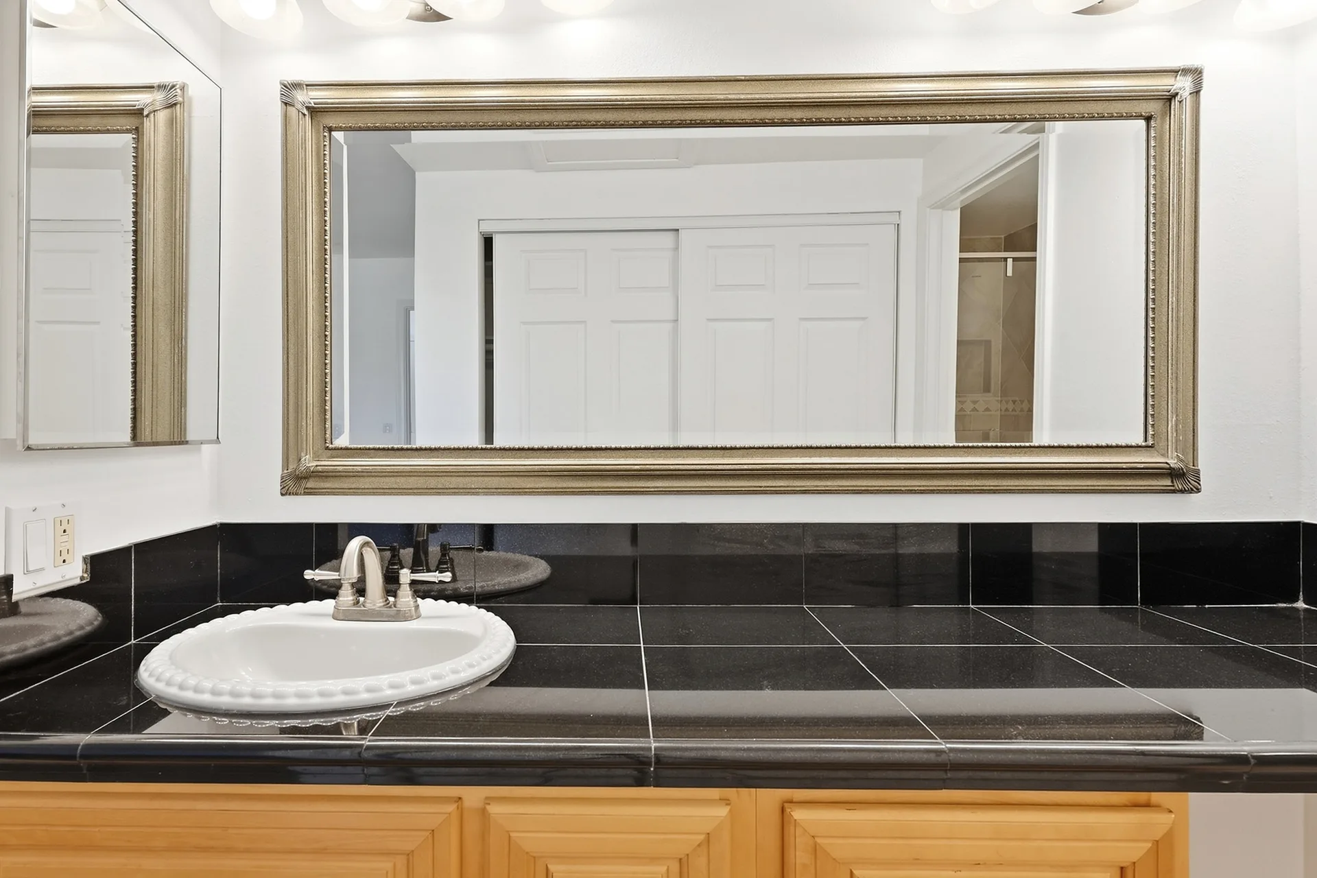 Bathroom vanity detail at 8 Silverwood with light wood cabinets and an integrated sink
