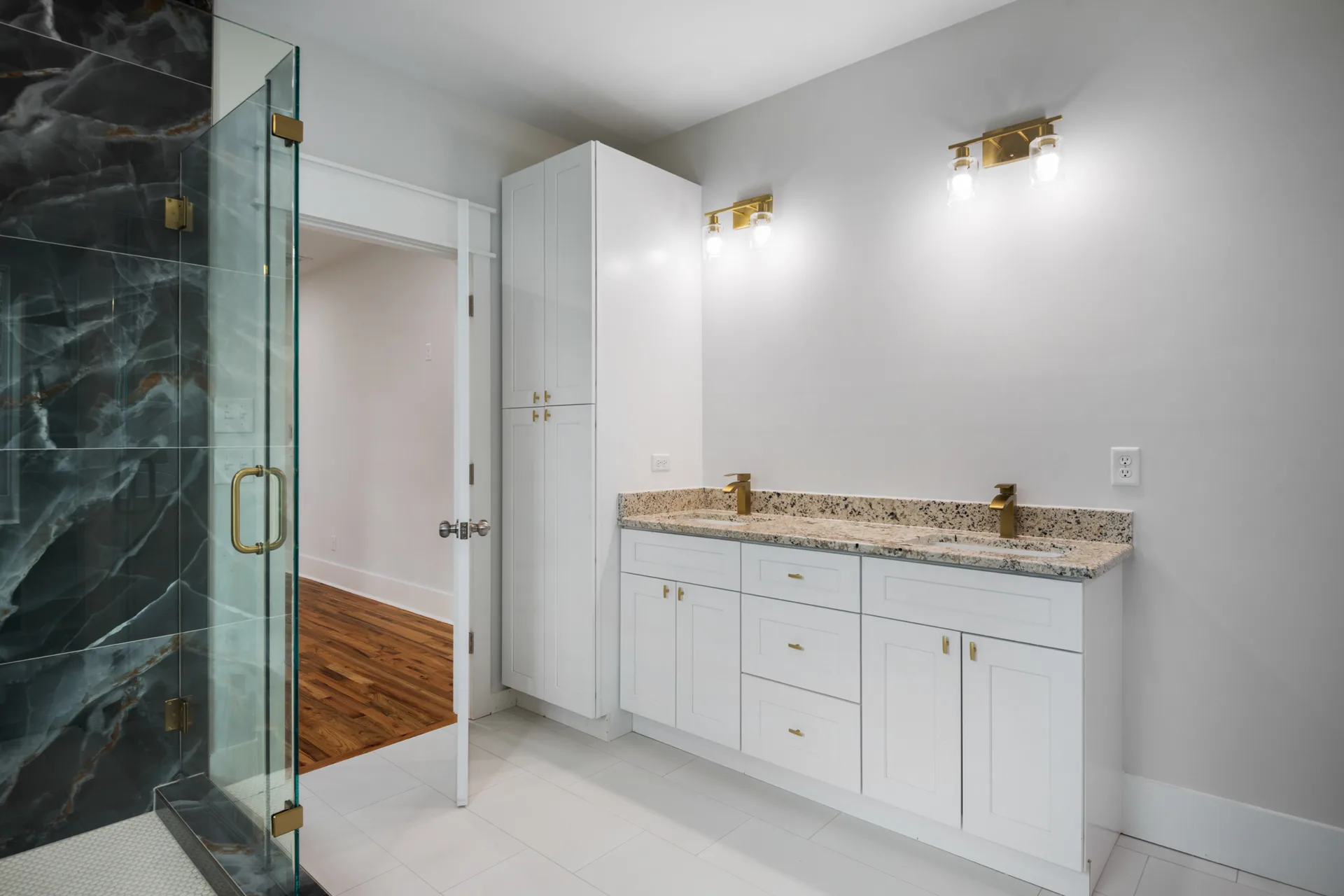 Double vanity with granite counters and gold hardware
