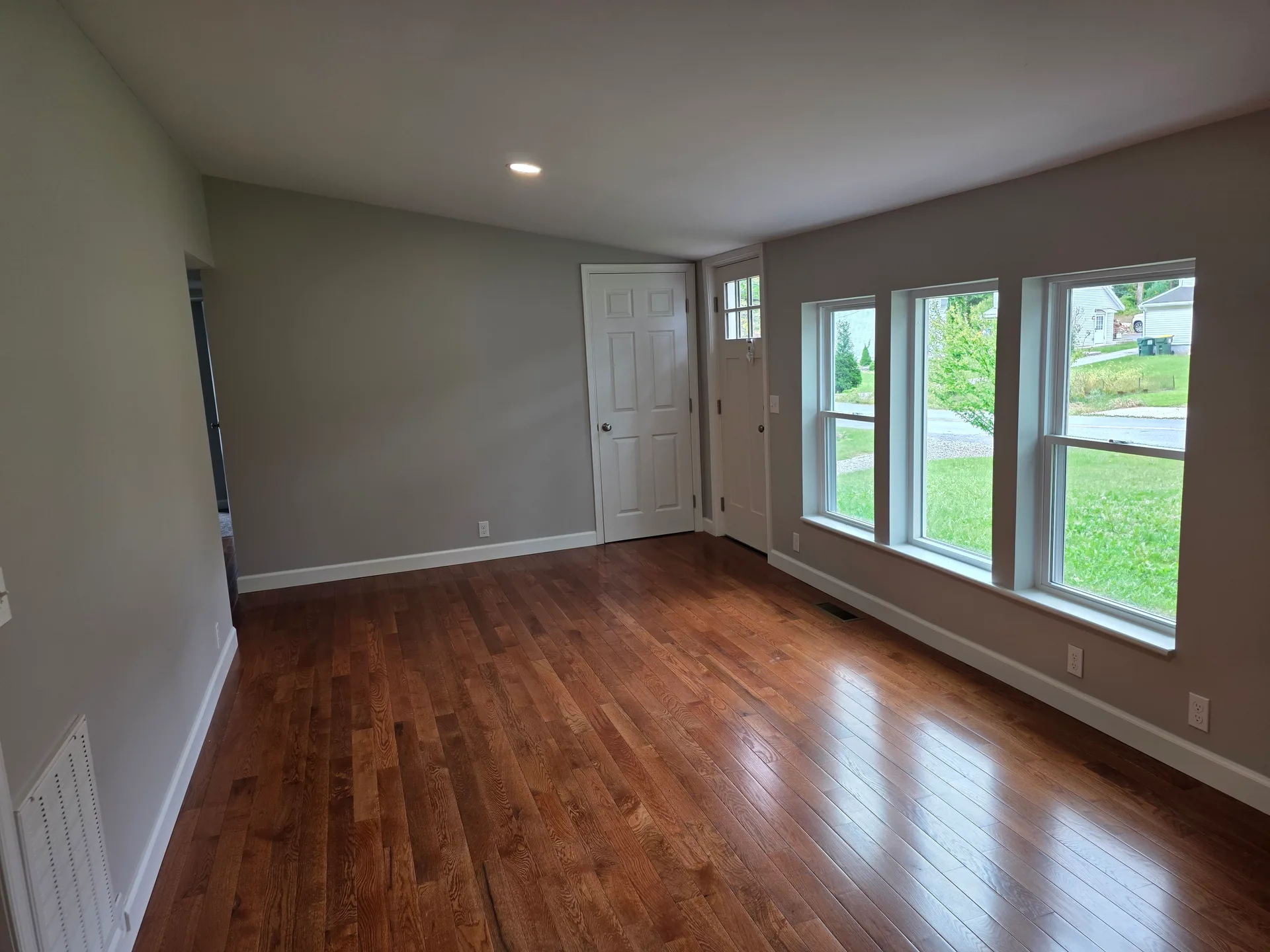 Living room with dark hardwood floors and a slanted ceiling