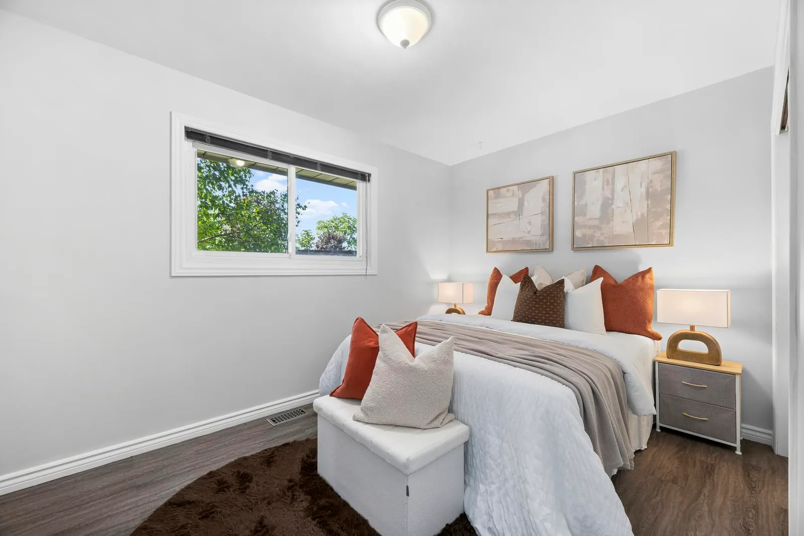 Primary bedroom with light grey walls and hardwood flooring