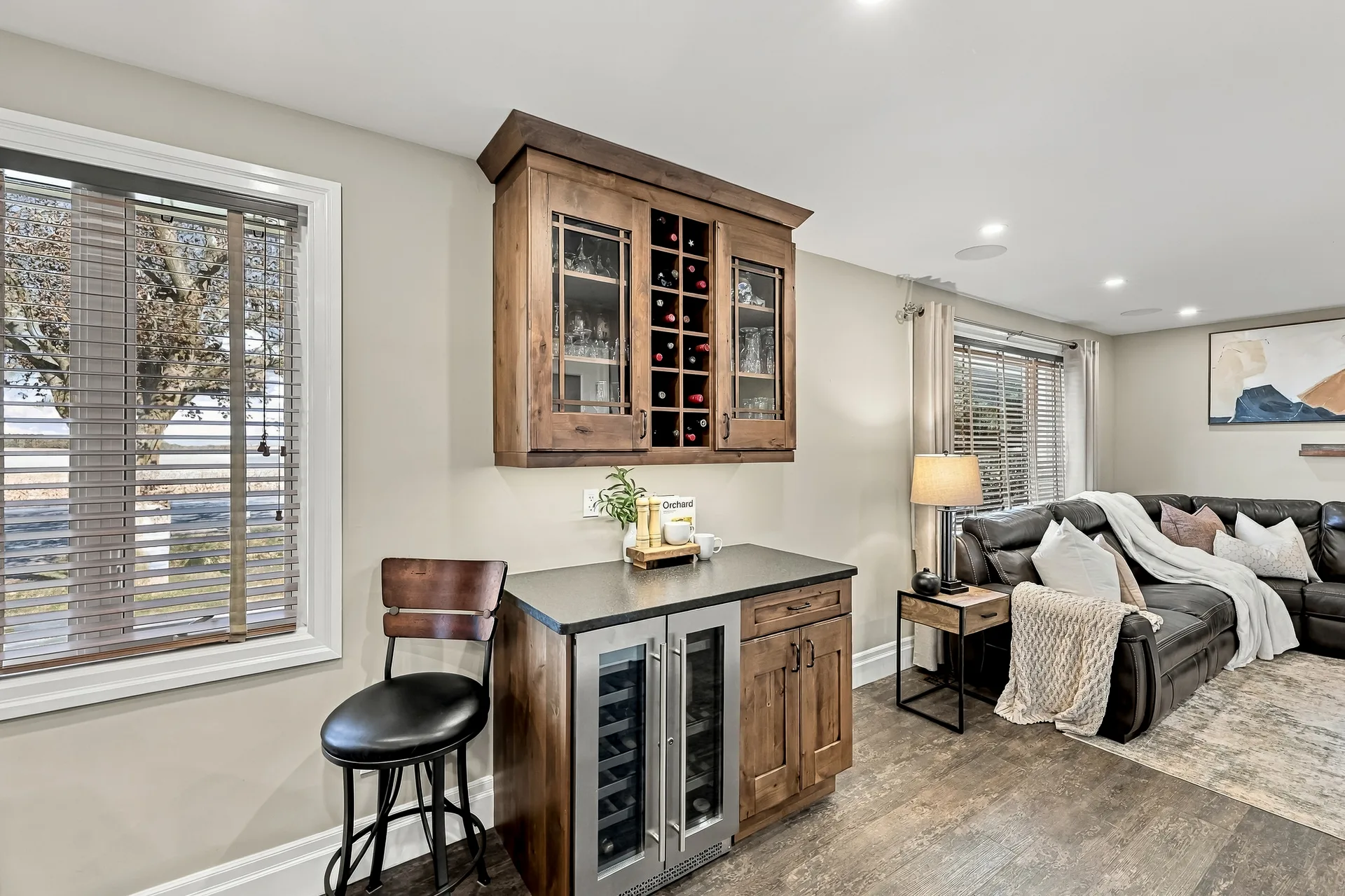 Wet bar with wood cabinetry and built-in wine fridge off the living room
