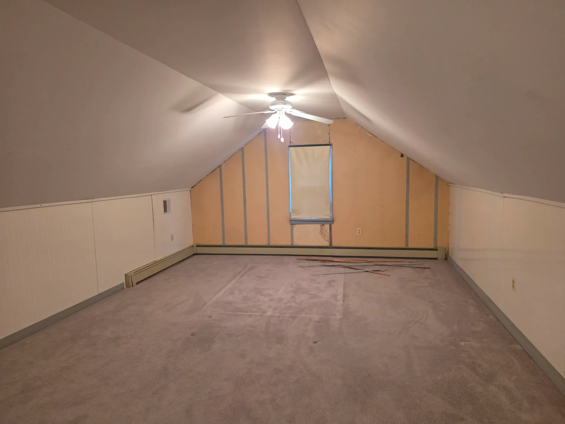 Attic bedroom with sloped ceiling, ceiling fan with lights, and single window