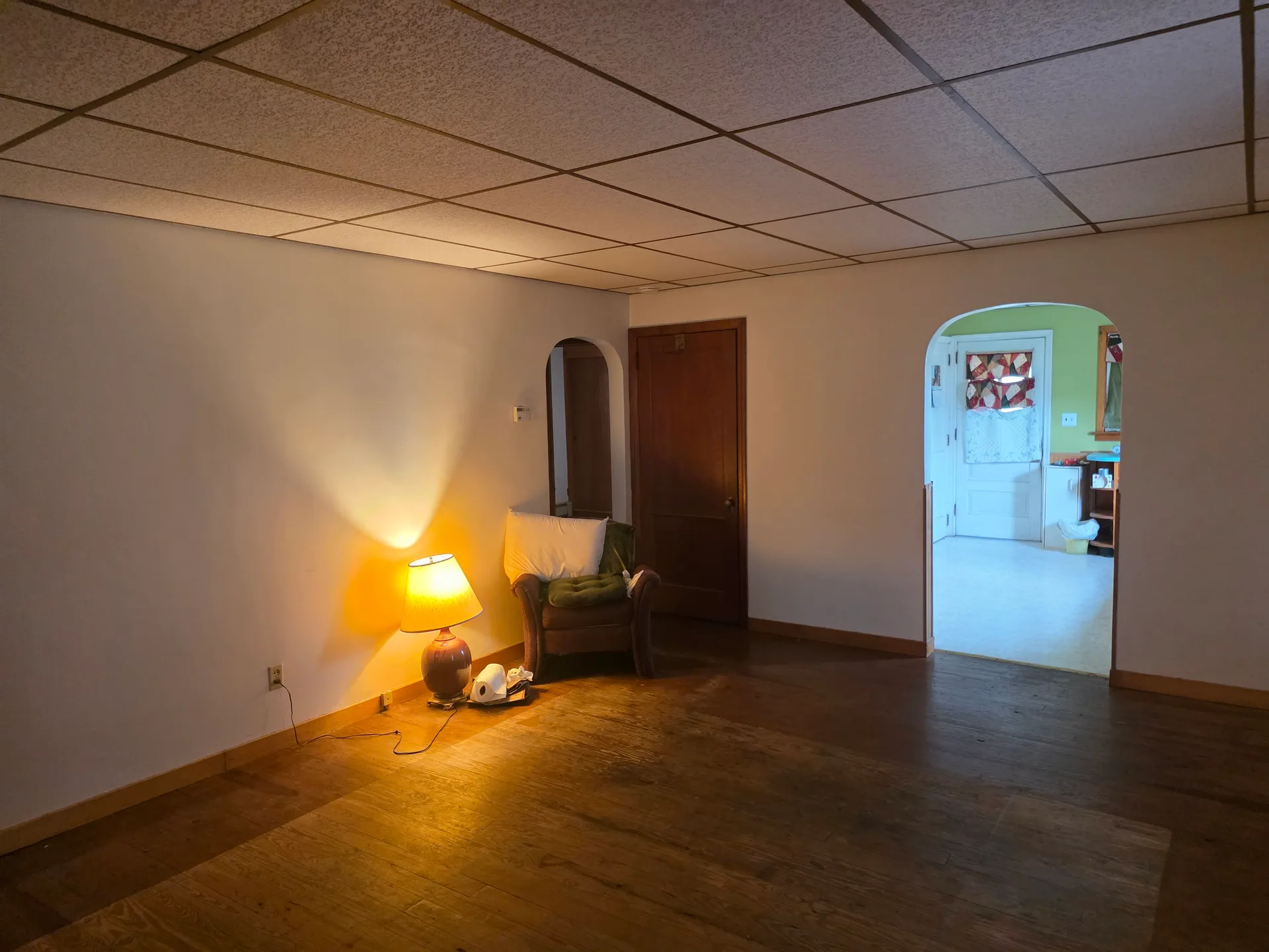 Living room with hardwood flooring and view into adjacent room