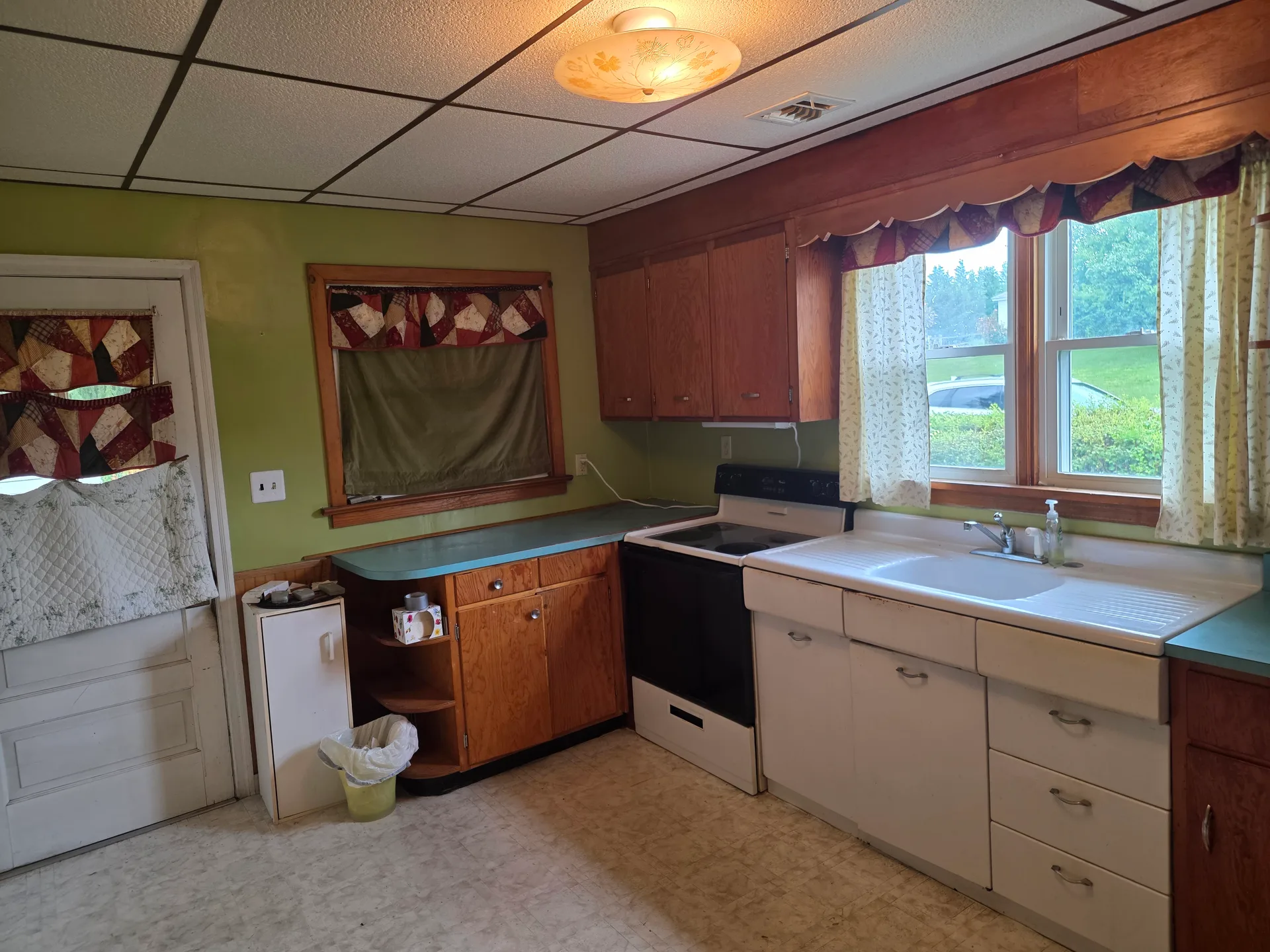 Kitchen with wood and white cabinets, laminate countertops, and ceiling fixture