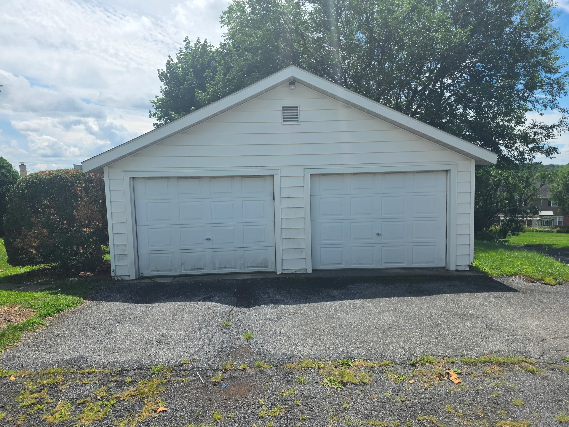 Detached two-car garage with white siding and asphalt driveway