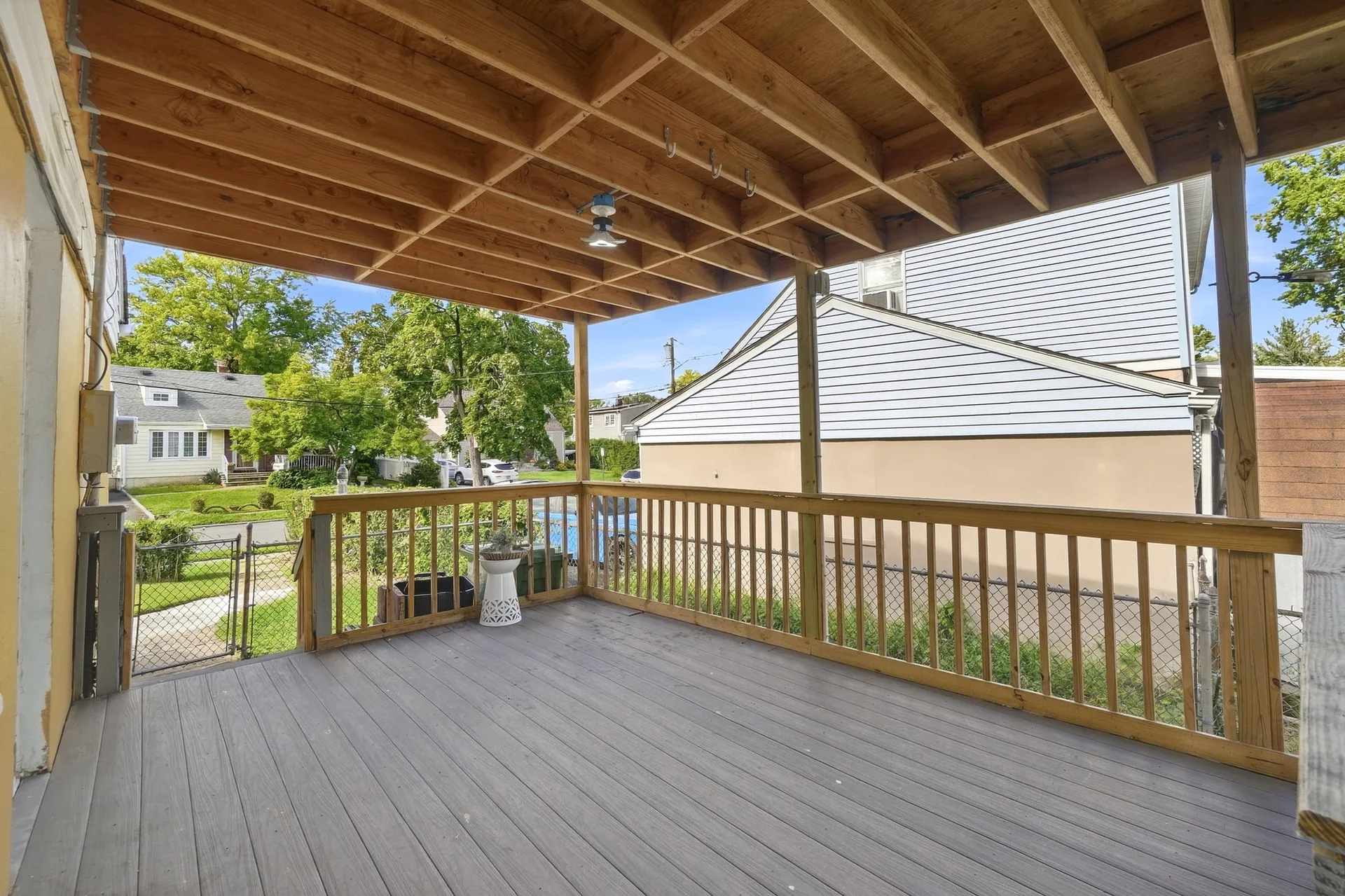 Covered wooden deck with exposed timber ceiling joists and composite decking
